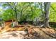 View of the large backyard featuring a wooden shed, lush trees, grass and a privacy fence at 1326 Metropolitan Se Ave, Atlanta, GA 30316