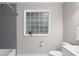 Bathroom featuring gray tiled shower, patterned glass block window, and white marble tiled floors at 1326 Metropolitan Se Ave, Atlanta, GA 30316