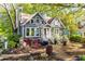 Charming two-story home with a landscaped front yard featuring a stone chimney and flowering bushes at 1326 Metropolitan Se Ave, Atlanta, GA 30316