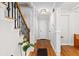 Staircase with dark metal spindles and hardwood floors in a neutrally painted hallway with a white door and trim at 1326 Metropolitan Se Ave, Atlanta, GA 30316