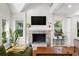 Bright living room featuring a stone fireplace, large windows, and a comfortable green sofa at 1326 Metropolitan Se Ave, Atlanta, GA 30316