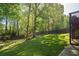 Large backyard with a well-manicured lawn and a wooden fence at 1570 Hill Crossing Ct, Grayson, GA 30017