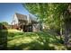 Green backyard with lawn, deck, and fence with mature tree providing shade at 1570 Hill Crossing Ct, Grayson, GA 30017