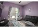 Bedroom with lavender walls, ceiling fan, and gray laminate flooring at 1570 Hill Crossing Ct, Grayson, GA 30017