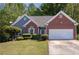 Charming home showcasing a well-manicured lawn and lush landscaping, enhancing its curb appeal at 1570 Hill Crossing Ct, Grayson, GA 30017