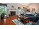Cozy living room featuring a brick fireplace, hardwood floors, and abundant natural light at 1570 Hill Crossing Ct, Grayson, GA 30017