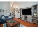 Spacious living room with hardwood floors, showcasing a modern entertainment center and comfortable seating at 1570 Hill Crossing Ct, Grayson, GA 30017