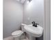 Powder room features a pedestal sink with black hardware, elongated toilet and fresh paint at 2077 Perkerson Rd, Atlanta, GA 30310