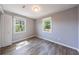 Bedroom featuring two windows, modern ceiling light, wood-look flooring, and neutral paint at 2077 Perkerson Rd, Atlanta, GA 30310