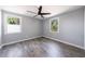 Bedroom with wood-look flooring, neutral walls, ceiling fan, and natural light from two windows at 2077 Perkerson Rd, Atlanta, GA 30310