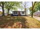 Charming home with dark trim, a cozy front deck, and well-maintained lawn with mature trees at 2077 Perkerson Rd, Atlanta, GA 30310