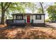 Charming single-story home features a red door, black shutters, and a cozy front porch at 2077 Perkerson Rd, Atlanta, GA 30310
