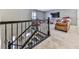Bonus room showcasing carpeted floors, a TV, and a toy area, accessed by an iron railing staircase at 815 Commerce Trl, Canton, GA 30114