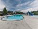 Large community pool featuring multiple swimming areas, lounge chairs, a slide, and surrounding greenery at 815 Commerce Trl, Canton, GA 30114