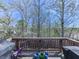 Back deck view showcasing the natural surroundings, trees, and distant neighborhood at 815 Commerce Trl, Canton, GA 30114