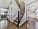 Elegant entryway with dark hardwood floors, a staircase with wrought iron railings, and access to various living spaces at 815 Commerce Trl, Canton, GA 30114