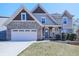 Attractive two-story home featuring a brick-accented garage, inviting front porch, and manicured front yard at 815 Commerce Trl, Canton, GA 30114