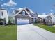 Charming two-story home featuring a brick-accented garage, manicured lawn, and a long driveway at 815 Commerce Trl, Canton, GA 30114