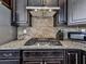 Kitchen featuring dark wood cabinets, granite countertops, stainless steel appliances, and a tiled backsplash at 815 Commerce Trl, Canton, GA 30114