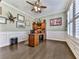 Well-lit office with wainscoting, hardwood floors, plantation shutters, and a built-in desk for a productive workspace at 815 Commerce Trl, Canton, GA 30114