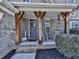 Inviting front porch area featuring rustic wooden support beams and traditional rocking chairs for relaxed outdoor seating at 815 Commerce Trl, Canton, GA 30114