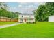 Charming two-story home features a well-manicured lawn, covered porch, and an orange front door at 90 Cerro St, Atlanta, GA 30314