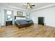 This spacious main bedroom has a tray ceiling, ceiling fan, bedside tables, and wood-look laminate flooring at 90 Cerro St, Atlanta, GA 30314