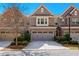 Charming brick-front townhome with a two-car garage and manicured landscaping for great curb appeal at 1427 Lanier Vista Dr, Sugar Hill, GA 30518