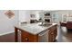 Granite kitchen island with stainless dishwasher overlooks the dining area and a cozy living room with fireplace at 1427 Lanier Vista Dr, Sugar Hill, GA 30518