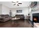 Cozy living room features hardwood floors, brown leather furniture, and a fireplace with a mounted TV at 1427 Lanier Vista Dr, Sugar Hill, GA 30518
