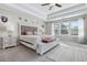 Bright main bedroom showcases a tray ceiling, large windows, and a comfortable bed with a tufted headboard at 1427 Lanier Vista Dr, Sugar Hill, GA 30518