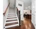Inviting home staircase featuring hardwood steps and floors plus classic wood banisters and trim at 1427 Lanier Vista Dr, Sugar Hill, GA 30518
