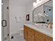 Bright bathroom featuring a glass shower, dual sinks, modern fixtures, and an arched mirror at 2637 Crestdale Se Cir, Atlanta, GA 30316