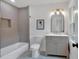Tastefully updated bathroom with tub, gray vanity, white marble countertop, and modern fixtures at 2637 Crestdale Se Cir, Atlanta, GA 30316
