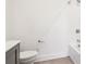 Bright bathroom featuring a toilet and a shower-bathtub combination with white tiles at 443 Plateau Nw Pl, Atlanta, GA 30309