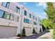 Exterior of modern townhomes featuring gray garage doors, landscaping, and a sunny day at 443 Plateau Nw Pl, Atlanta, GA 30309