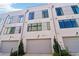 Exterior of modern townhome featuring a gray garage door, light fixtures, and landscaping at 443 Plateau Nw Pl, Atlanta, GA 30309