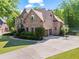 Elegant brick home features an attached two-car garage, a driveway with basketball goal, and lush landscaping at 602 Davenport Pl, Canton, GA 30115