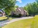 Beautiful brick house with a two-car garage, a long concrete driveway, a basketball goal, and a well-manicured lawn at 602 Davenport Pl, Canton, GA 30115