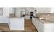 Bright kitchen features white cabinetry, stainless steel appliances, granite counters, and wood floors at 602 Davenport Pl, Canton, GA 30115