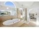 Bright bathroom featuring a soaking tub, glass enclosed shower, and view of outdoors at 602 Davenport Pl, Canton, GA 30115