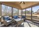 Relaxing screened porch featuring wicker furniture and views of wooded backyard at 602 Davenport Pl, Canton, GA 30115