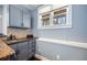 Cozy wet bar featuring blue cabinetry, a sink, granite countertops and a window with a view of the yard at 602 Davenport Pl, Canton, GA 30115