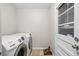 This laundry room features a washing machine, dryer, tile floor and a window at 1618 Cooper Lake Se Rd, Smyrna, GA 30082