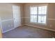 Bedroom with wall trim, a door, and a window with blinds to provide natural light at 1910 Charleston Oak Cir, Lawrenceville, GA 30043