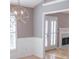 Dining area with white trim, wainscotting, fireplace and a view of double french doors at 1910 Charleston Oak Cir, Lawrenceville, GA 30043