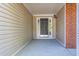 Inviting front entry featuring a black door, beige siding, and a covered porch at 1910 Charleston Oak Cir, Lawrenceville, GA 30043