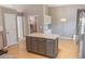 Kitchen with gray island, granite countertop, wood floors, stainless steel appliances, and ample storage at 1910 Charleston Oak Cir, Lawrenceville, GA 30043