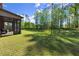 Expansive backyard featuring mature trees and well-manicured lawn at 404 Prague Way, Hampton, GA 30228