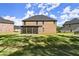 Back of brick home shows large lawn, screened in porch, and well-kept backyard at 404 Prague Way, Hampton, GA 30228